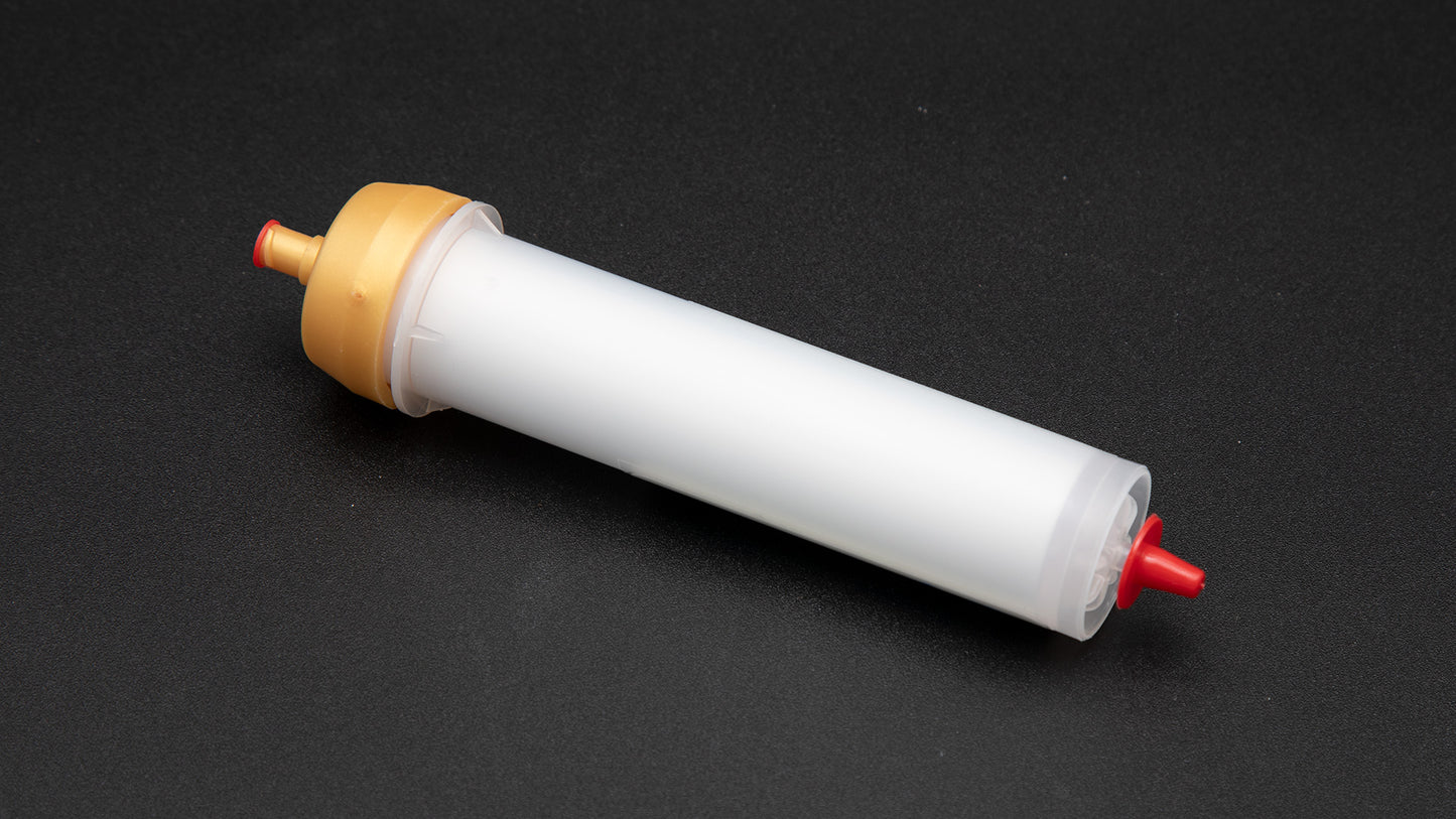 A small white tube with gold and red caps displayed on a black background, creating a striking visual contrast between the two elements.