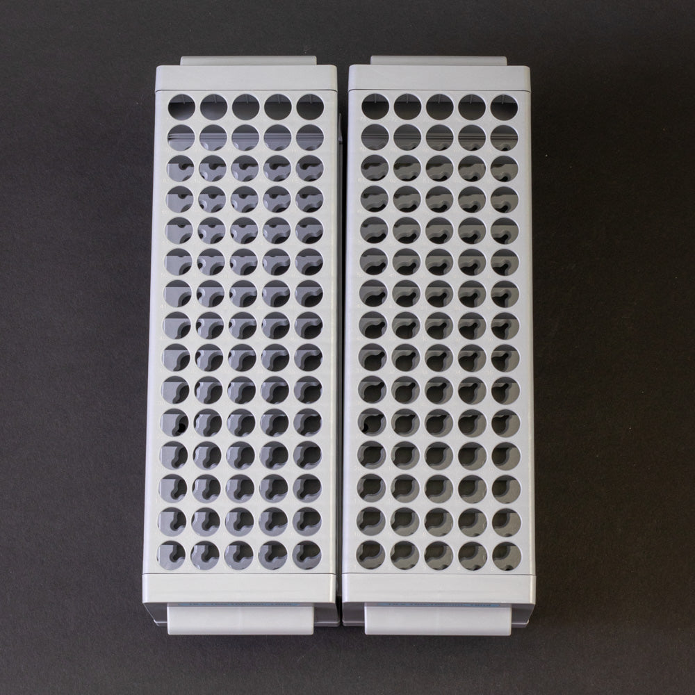 A pair of gray plastic shelves with perforated design, allowing for location and storage of vials.
