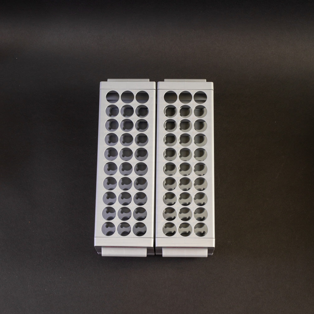 A pair of gray plastic shelves with perforated design, allowing for location and storage of vials.