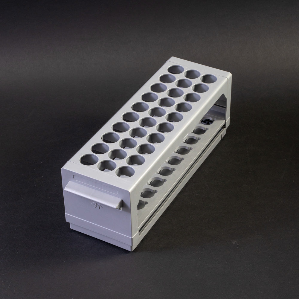 A gray plastic shelf with perforated design, allowing for location and storage of vials.