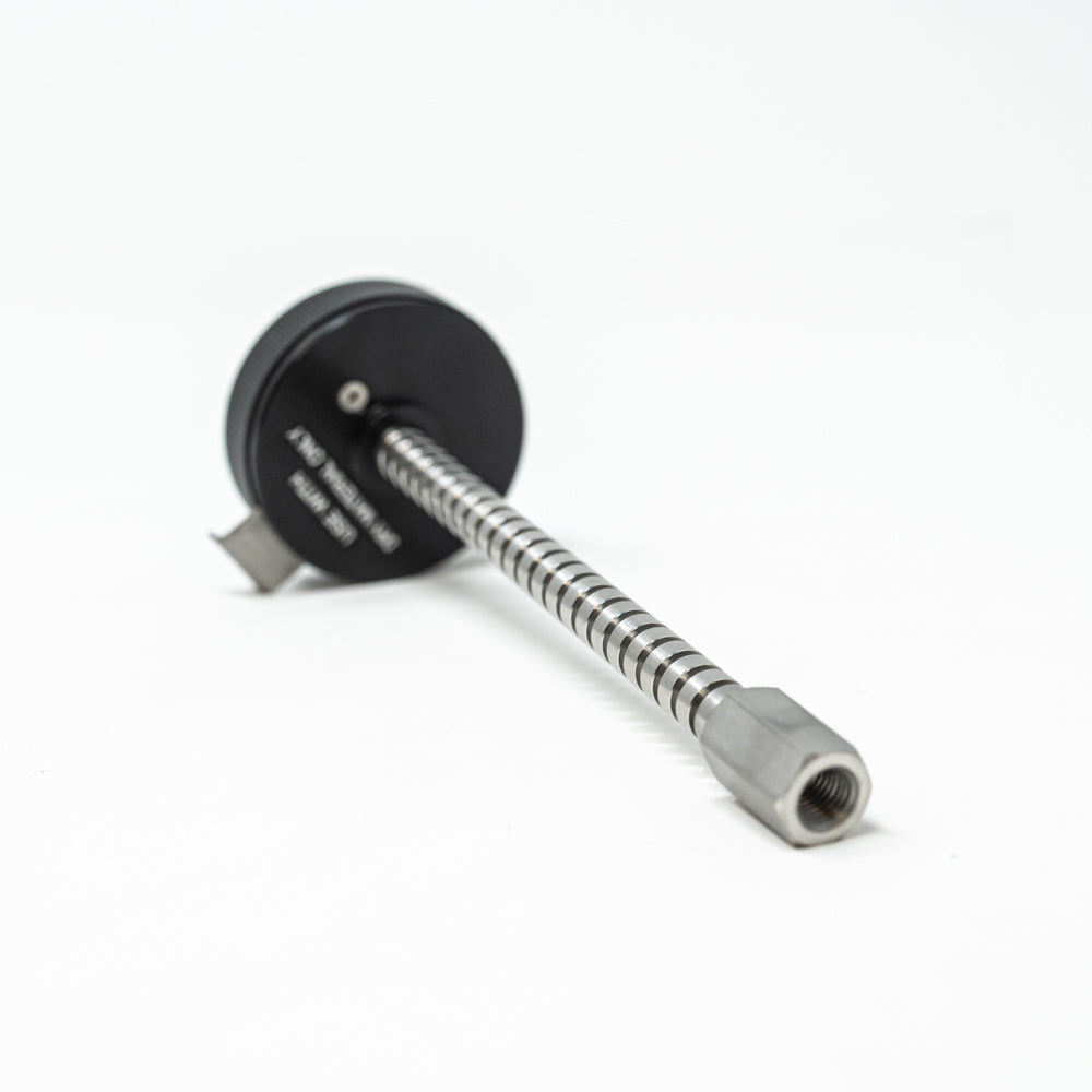 A stainless steel object featuring a sleek rod, showcasing a minimalist design and modern aesthetic.