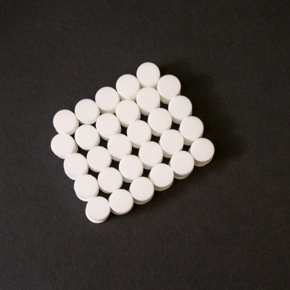 A cluster of white circular objects positioned on a black surface.