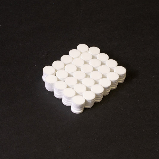 A cluster of white circular objects positioned on a black surface.