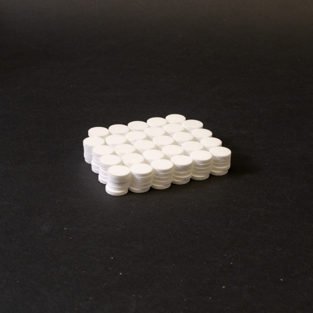 A cluster of white circular objects positioned on a black surface.