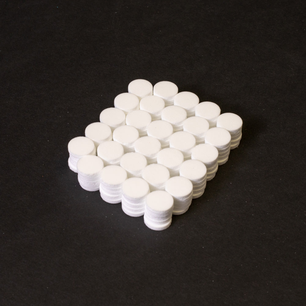 A cluster of white circular objects positioned on a black surface.