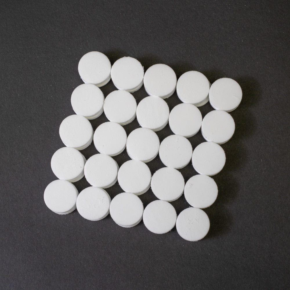 A cluster of white circular objects positioned on a black surface.