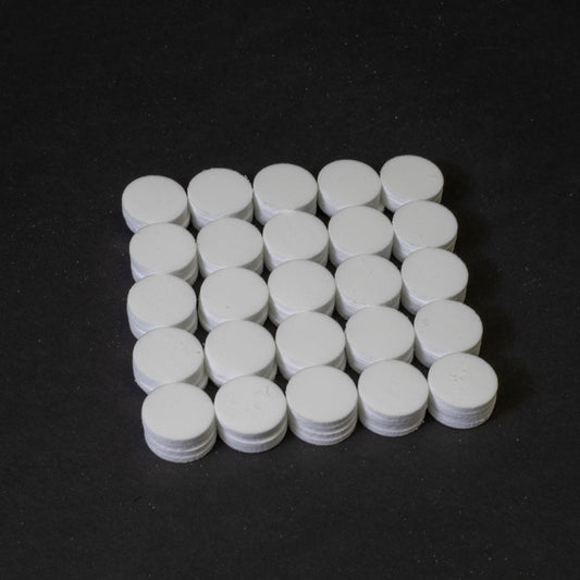 A cluster of white circular objects positioned on a black surface.