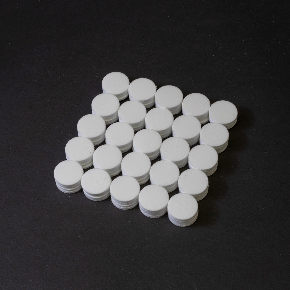 A cluster of white circular objects positioned on a black surface.