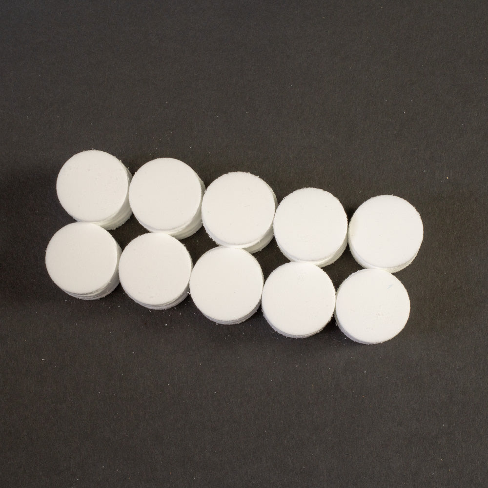 A cluster of white circular objects positioned on a black surface.