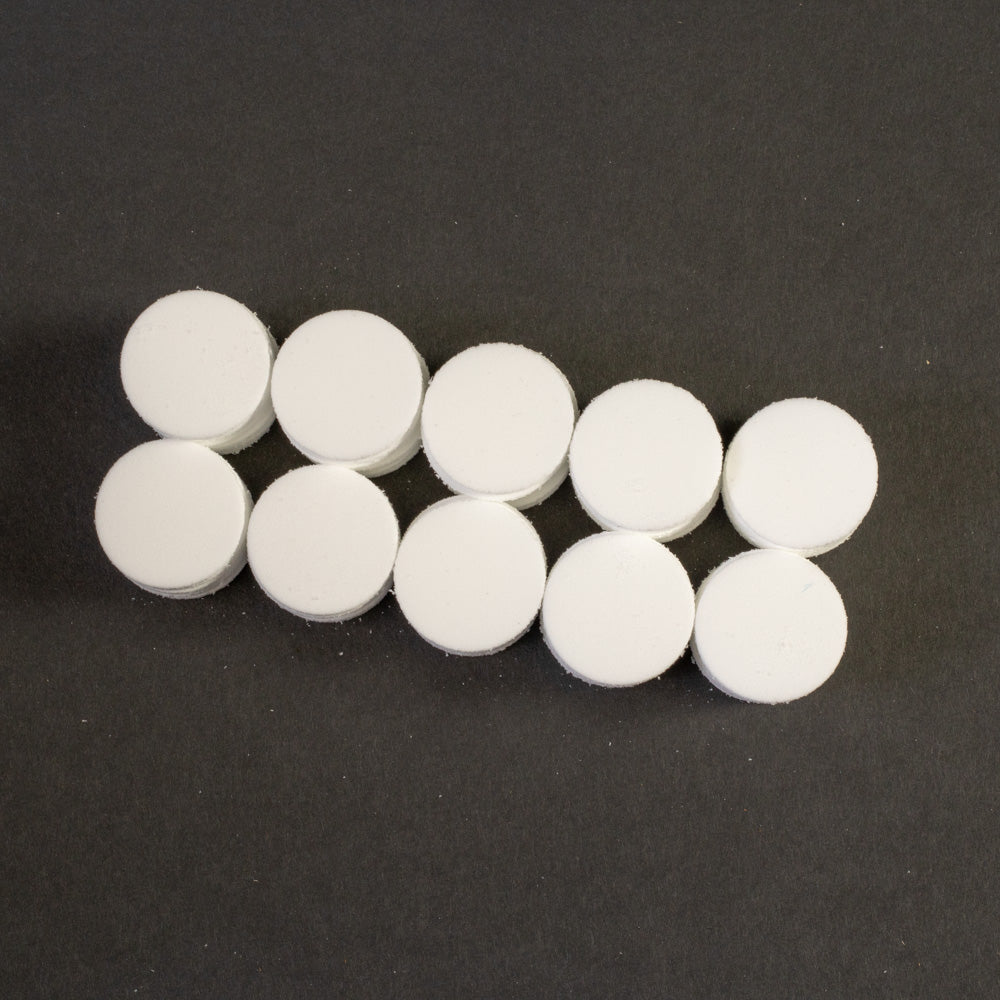 A cluster of white circular objects positioned on a black surface.