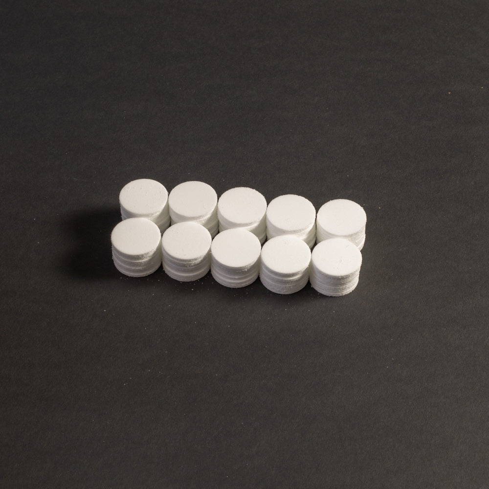 A cluster of white circular objects positioned on a black surface.