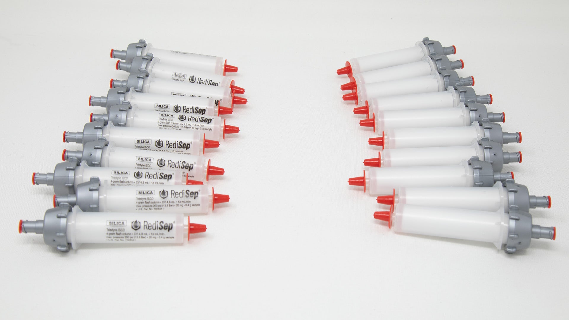 A group of plastic tubes with red and silver caps, positioned side by side, emphasizing their contrasting colors and forms.
