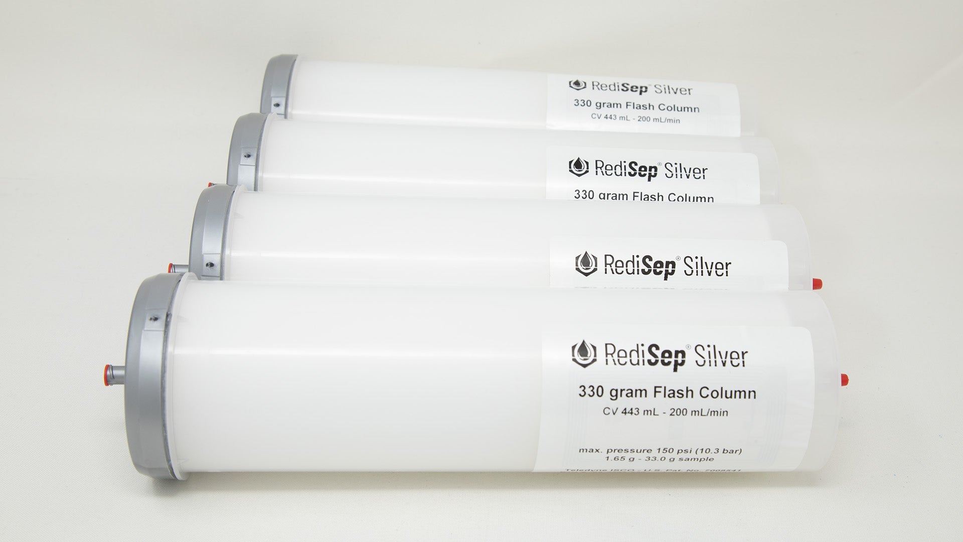 A group of plastic tubes with red and silver caps, positioned side by side, emphasizing their contrasting colors and forms.