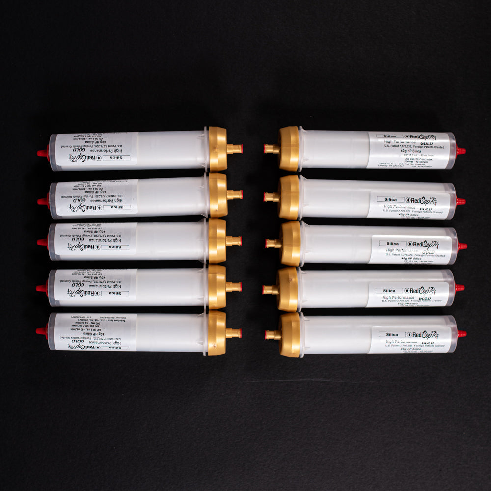 A group of small white tubes with gold and red caps displayed on a black background, creating a striking visual contrast between the two elements.