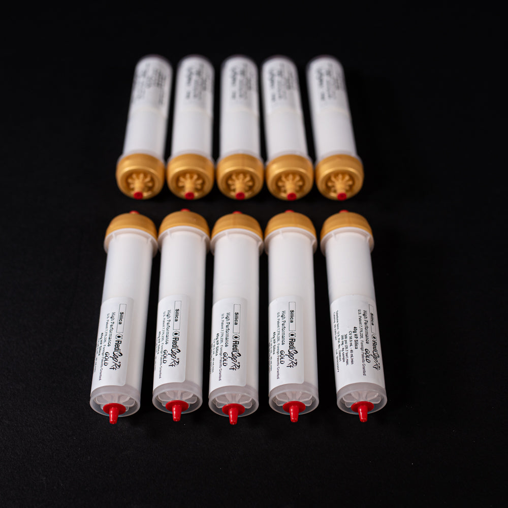 A group of small white tubes with gold and red caps displayed on a black background, creating a striking visual contrast between the two elements.