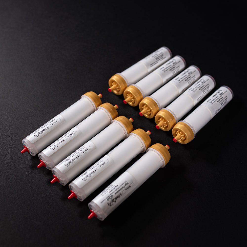 A group of small white tubes with gold and red caps displayed on a black background, creating a striking visual contrast between the two elements.