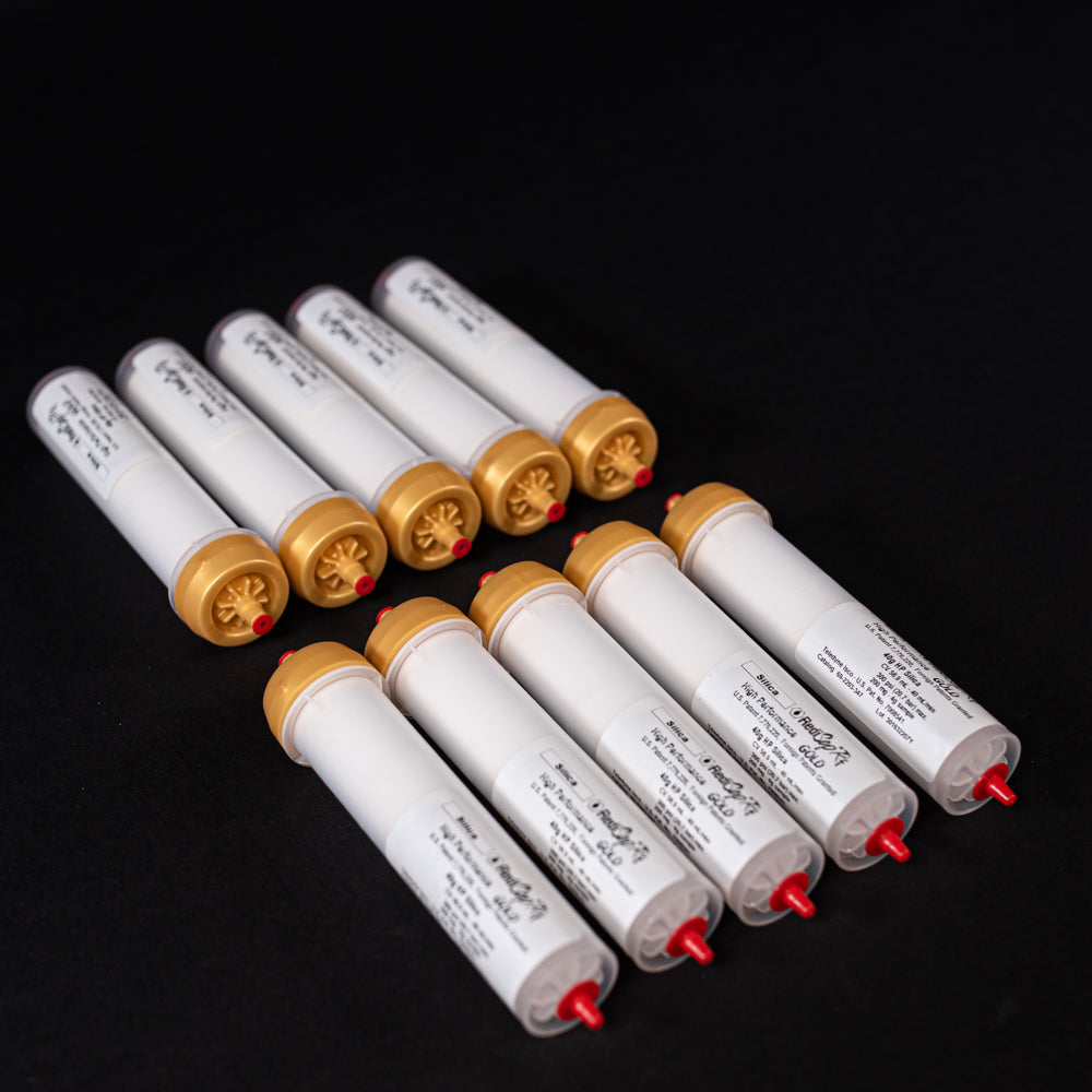 A group of small white tubes with gold and red caps displayed on a black background, creating a striking visual contrast between the two elements.