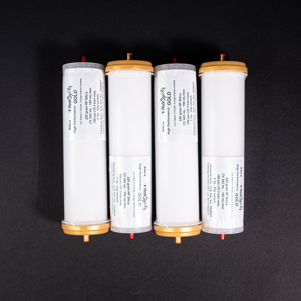 A group of small white tubes with gold and red caps displayed on a black background, creating a striking visual contrast between the two elements.