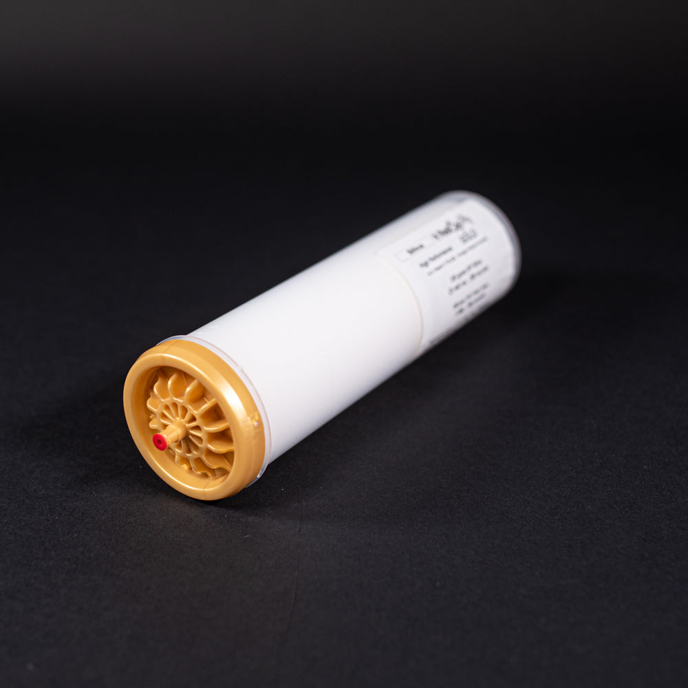 A small white tube with gold and red caps displayed on a black background, creating a striking visual contrast between the two elements.