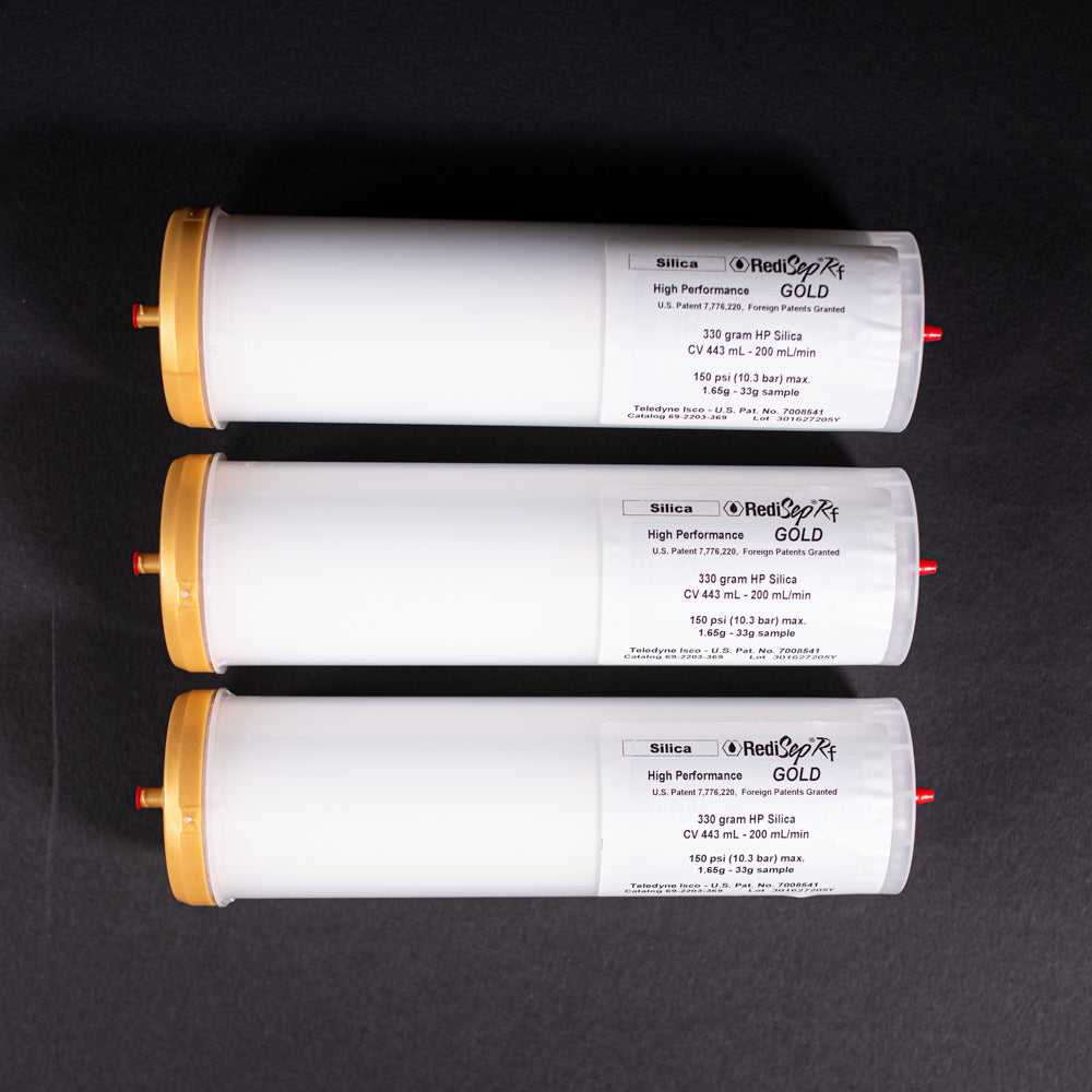 A group of small white tubes with gold and red caps displayed on a black background, creating a striking visual contrast between the two elements.