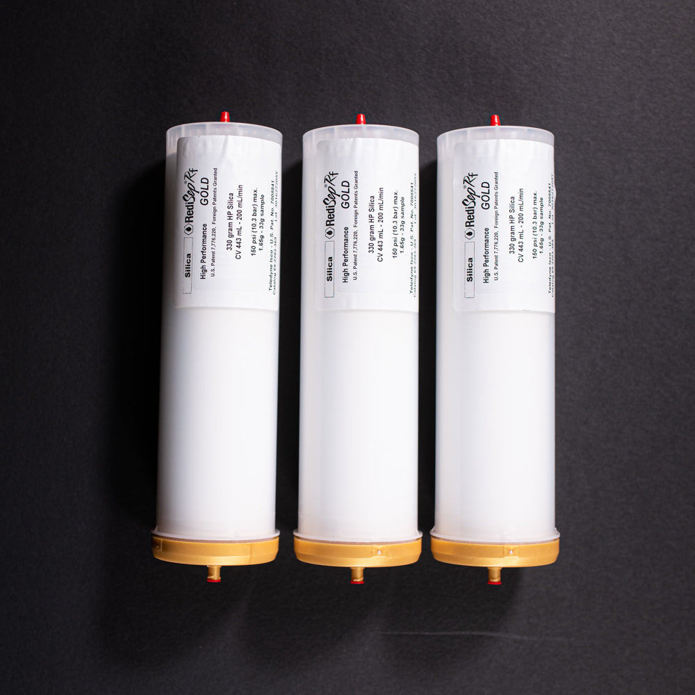 FA group of small white tubes with gold and red caps displayed on a black background, creating a striking visual contrast between the two elements.
