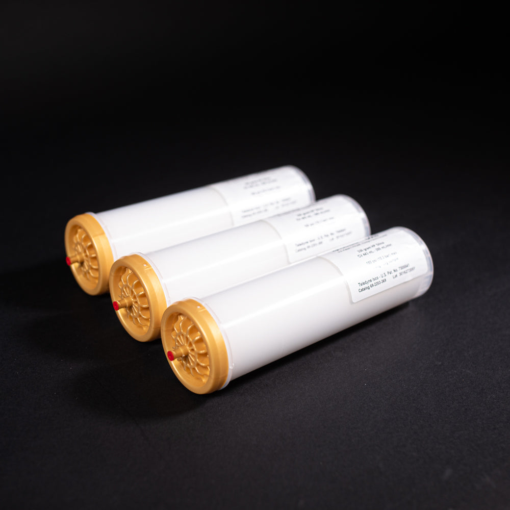 A group of small white tubes with gold and red caps displayed on a black background, creating a striking visual contrast between the two elements.