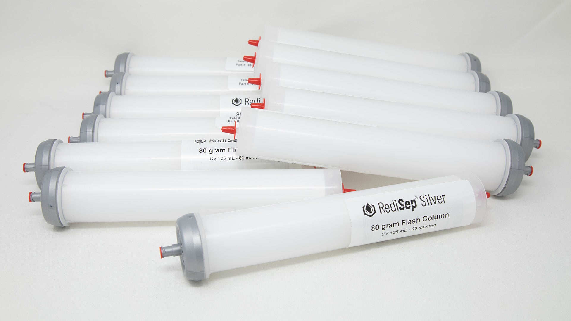 A group of plastic tubes with red and silver caps, positioned side by side, emphasizing their contrasting colors and forms.