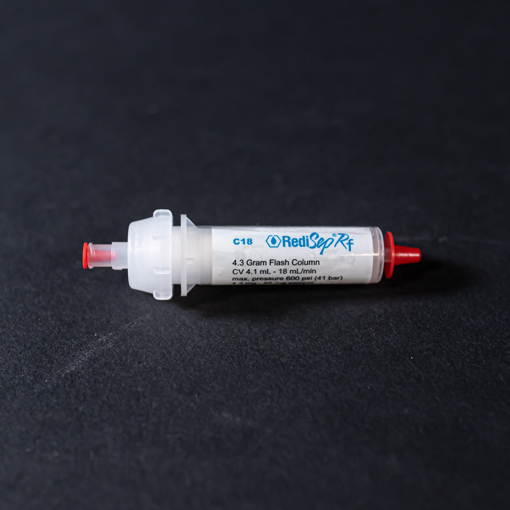 A white tube with red caps displayed on a black background, creating a striking visual contrast between the two elements.