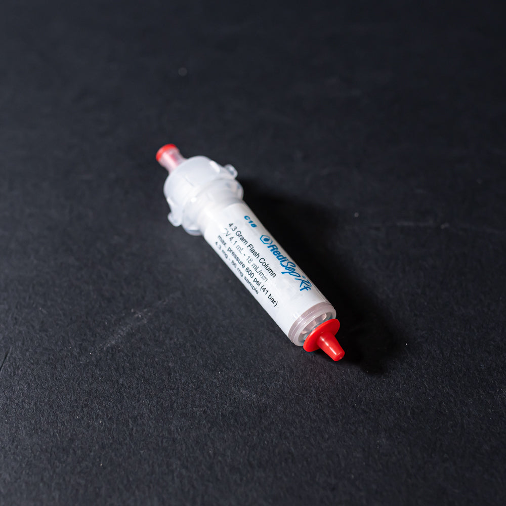 A white tube with red caps displayed on a black background, creating a striking visual contrast between the two elements.