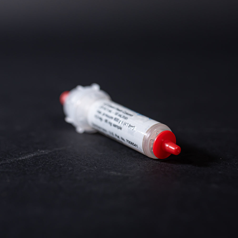 A white tube with red caps displayed on a black background, creating a striking visual contrast between the two elements.