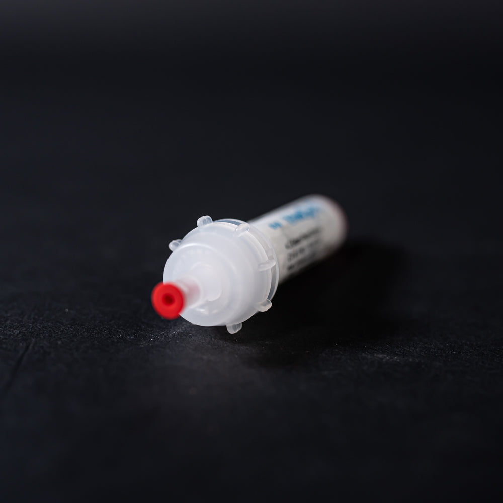 A white tube with red caps displayed on a black background, creating a striking visual contrast between the two elements.