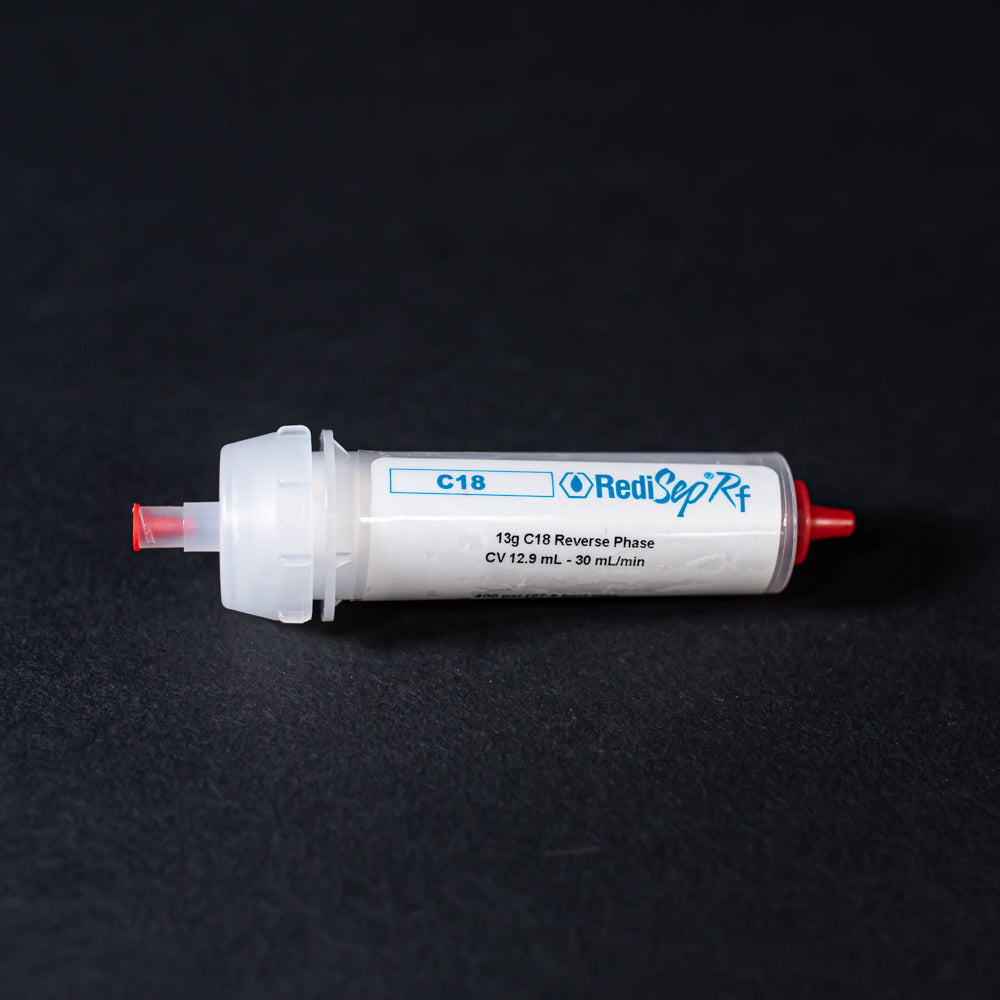 A small white tube with red caps displayed on a black background, creating a striking visual contrast between the two elements.