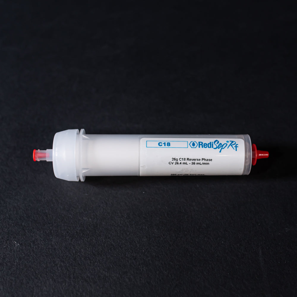 A small white tube with red caps displayed on a black background, creating a striking visual contrast between the two elements.