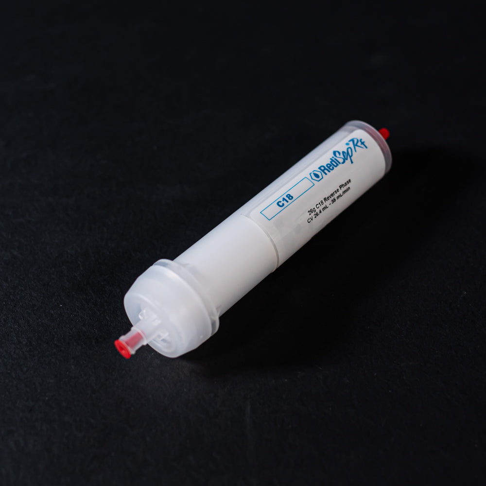 A small white tube with red caps displayed on a black background, creating a striking visual contrast between the two elements.