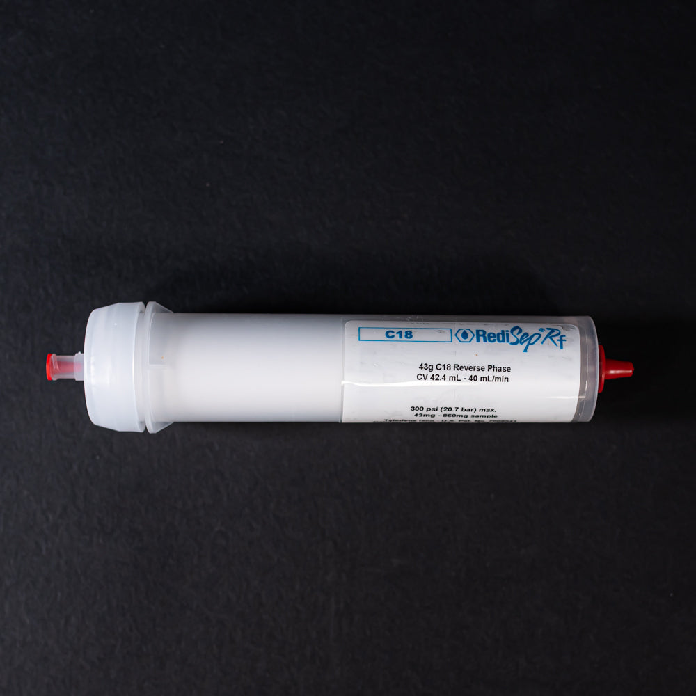 A small white tube with red caps displayed on a black background, creating a striking visual contrast between the two elements.