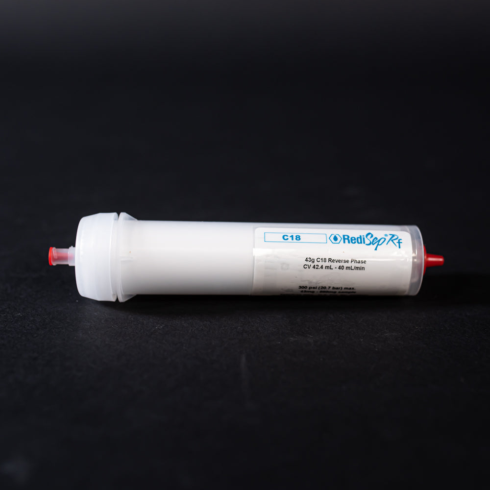 A small white tube with red caps displayed on a black background, creating a striking visual contrast between the two elements.