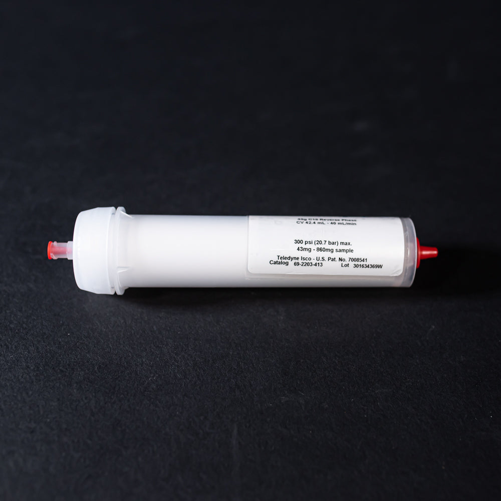 A small white tube with red caps displayed on a black background, creating a striking visual contrast between the two elements.