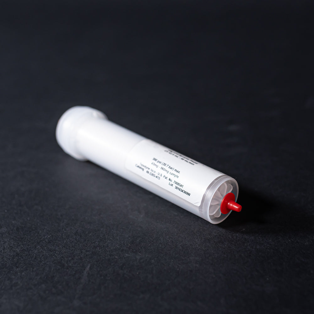 A small white tube with red caps displayed on a black background, creating a striking visual contrast between the two elements.