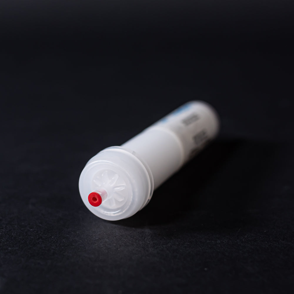 A small white tube with red caps displayed on a black background, creating a striking visual contrast between the two elements.