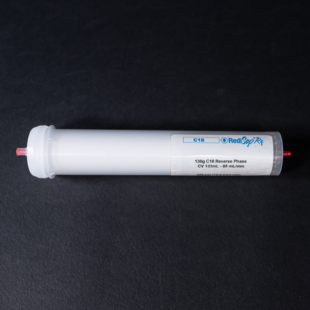 A small white tube with red caps displayed on a black background, creating a striking visual contrast between the two elements.