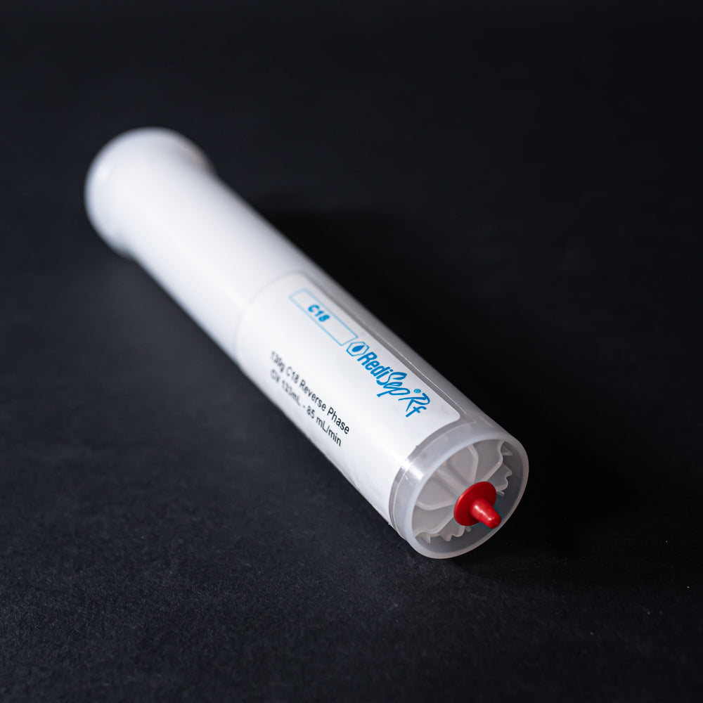 A small white tube with red caps displayed on a black background, creating a striking visual contrast between the two elements.