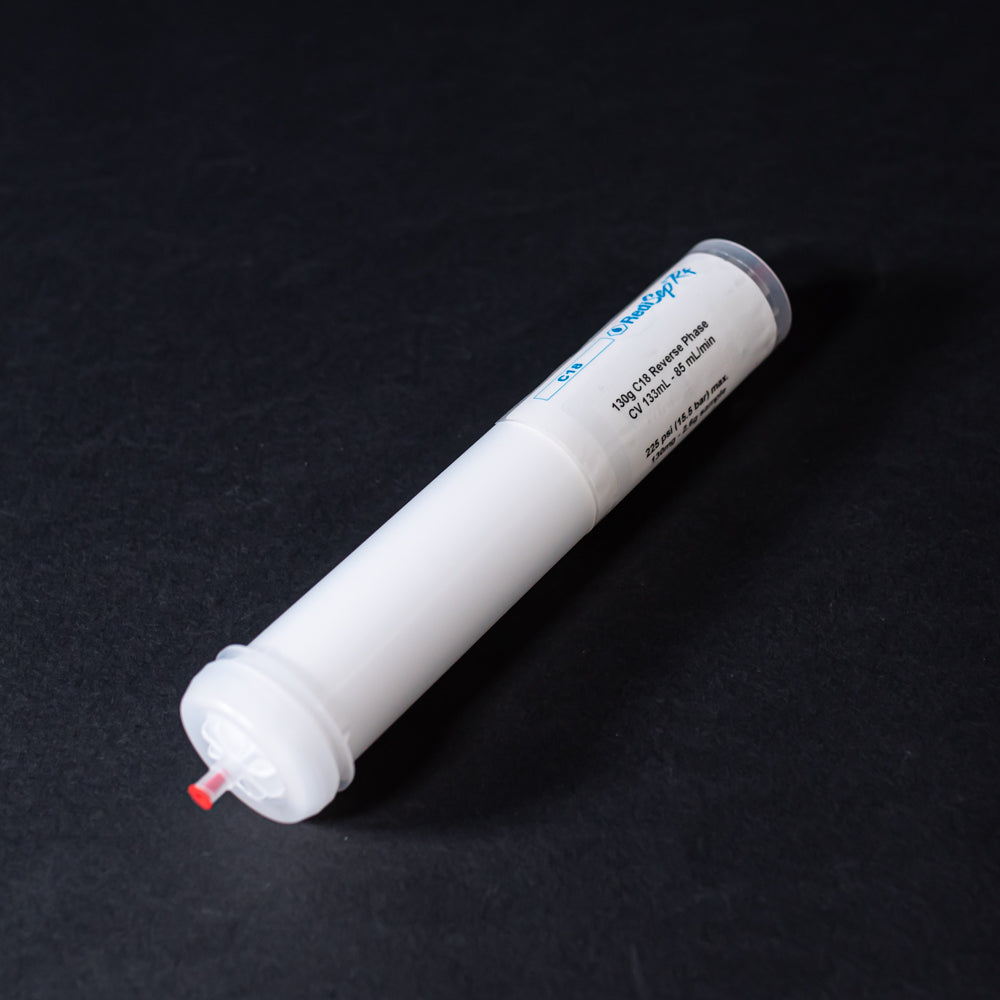 A small white tube with red caps displayed on a black background, creating a striking visual contrast between the two elements.