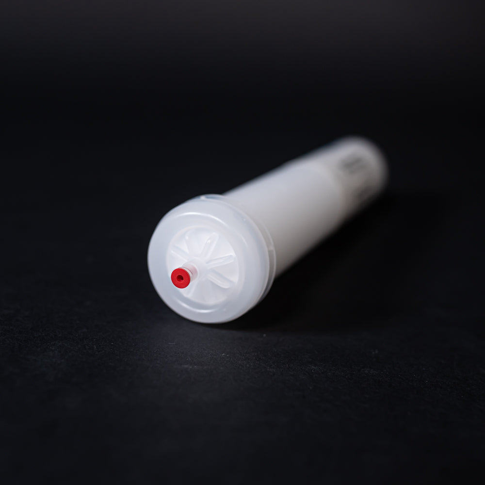 A small white tube with red caps displayed on a black background, creating a striking visual contrast between the two elements.