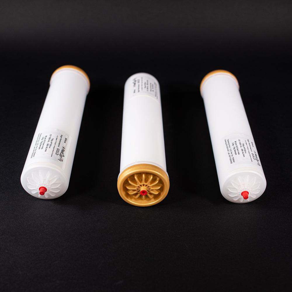 A group of small white tubes with gold and red caps displayed on a black background, creating a striking visual contrast between the two elements.