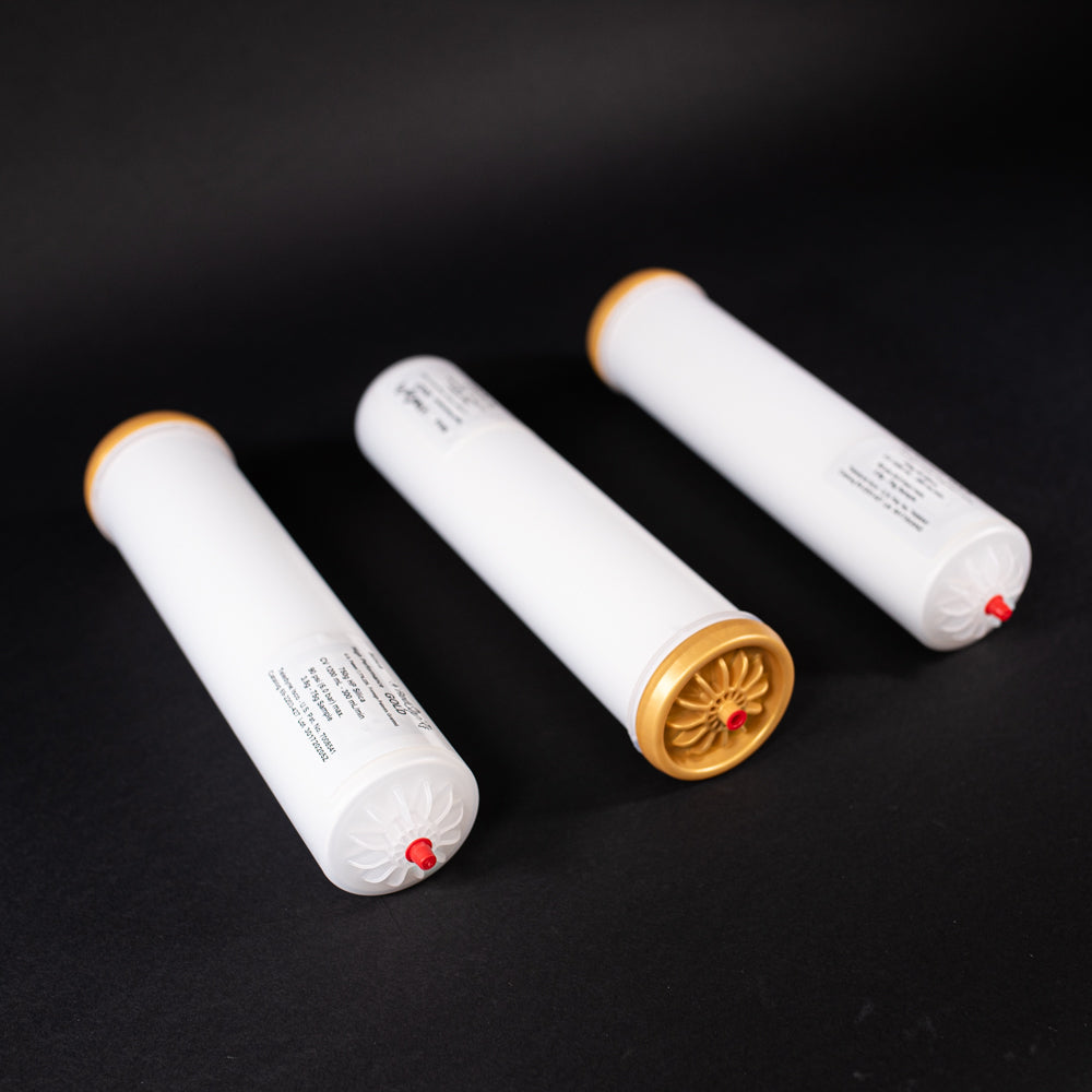 A group of small white tubes with gold and red caps displayed on a black background, creating a striking visual contrast between the two elements.