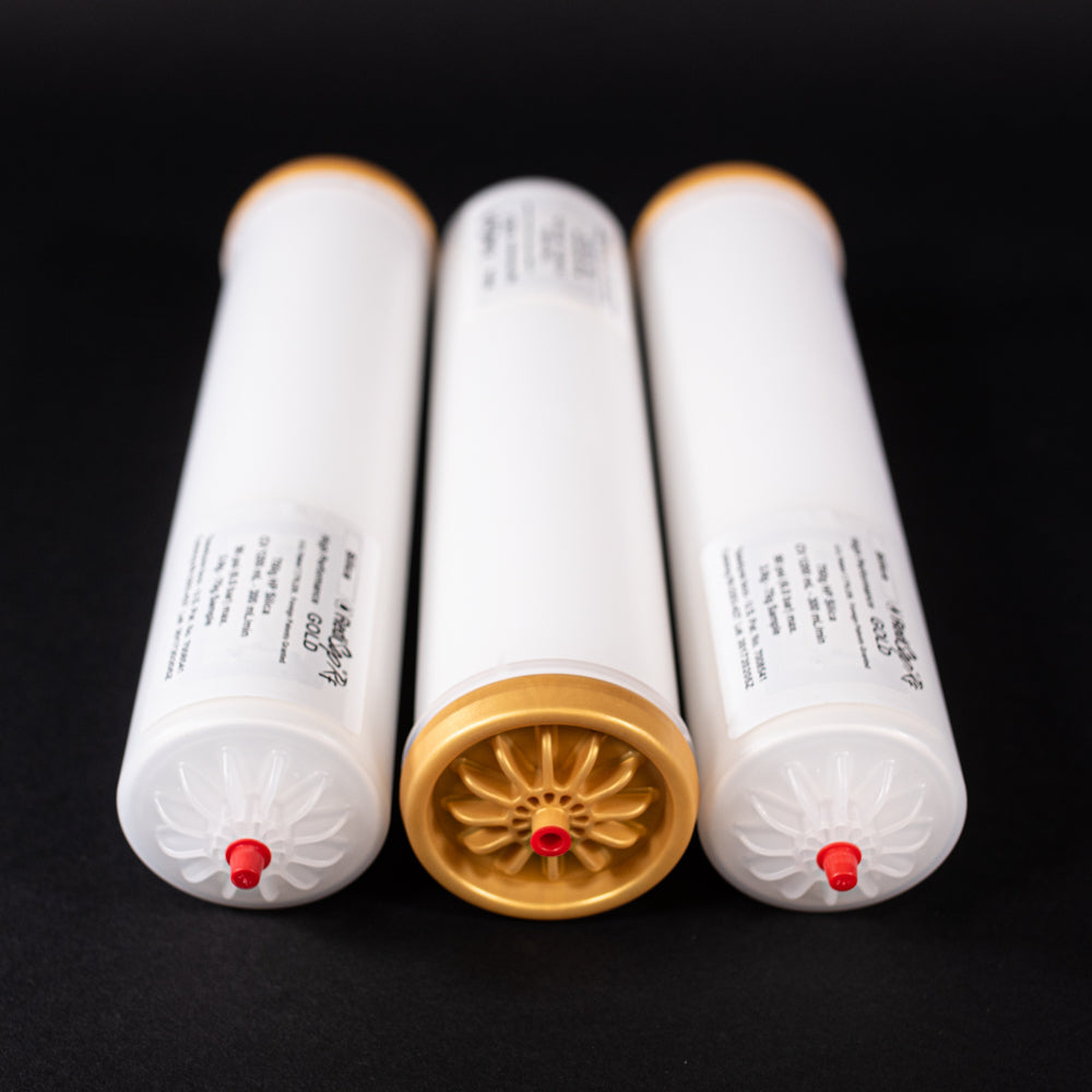 A group of small white tubes with gold and red caps displayed on a black background, creating a striking visual contrast between the two elements.