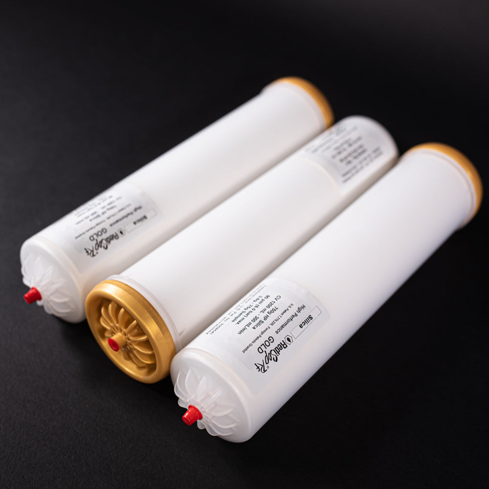 A group of small white tubes with gold and red caps displayed on a black background, creating a striking visual contrast between the two elements.