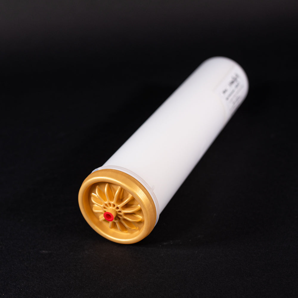 A small white tube with gold and red caps displayed on a black background, creating a striking visual contrast between the two elements.