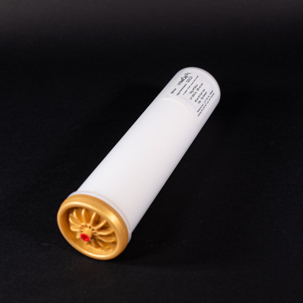 A small white tube with gold and red caps displayed on a black background, creating a striking visual contrast between the two elements.
