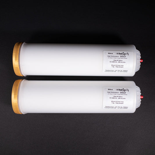 A group of small white tubes with gold and red caps displayed on a black background, creating a striking visual contrast between the two elements.